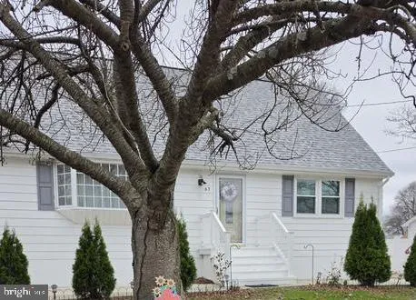 a front view of a house with a tree