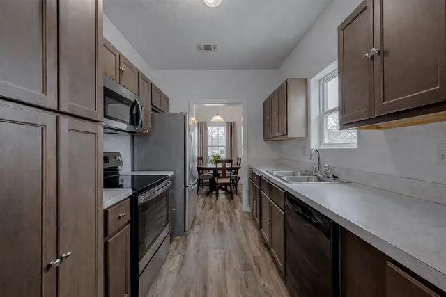 a kitchen with granite countertop a sink stove and cabinets