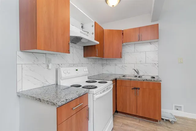 a kitchen with stainless steel appliances granite countertop a sink stove and cabinets