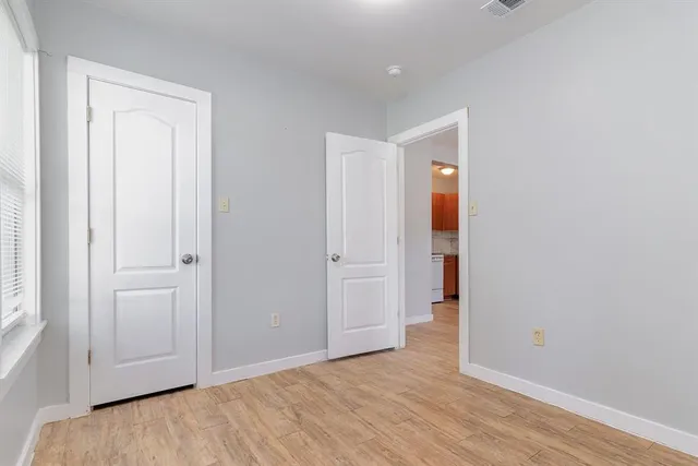 an empty room with wooden floor and closet