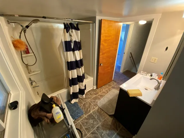 a bathroom with a bathtub sink and mirror