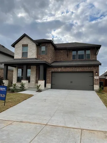 a front view of a house with yard and parking