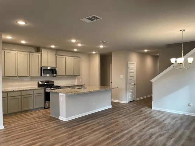 a kitchen with a sink stove and refrigerator