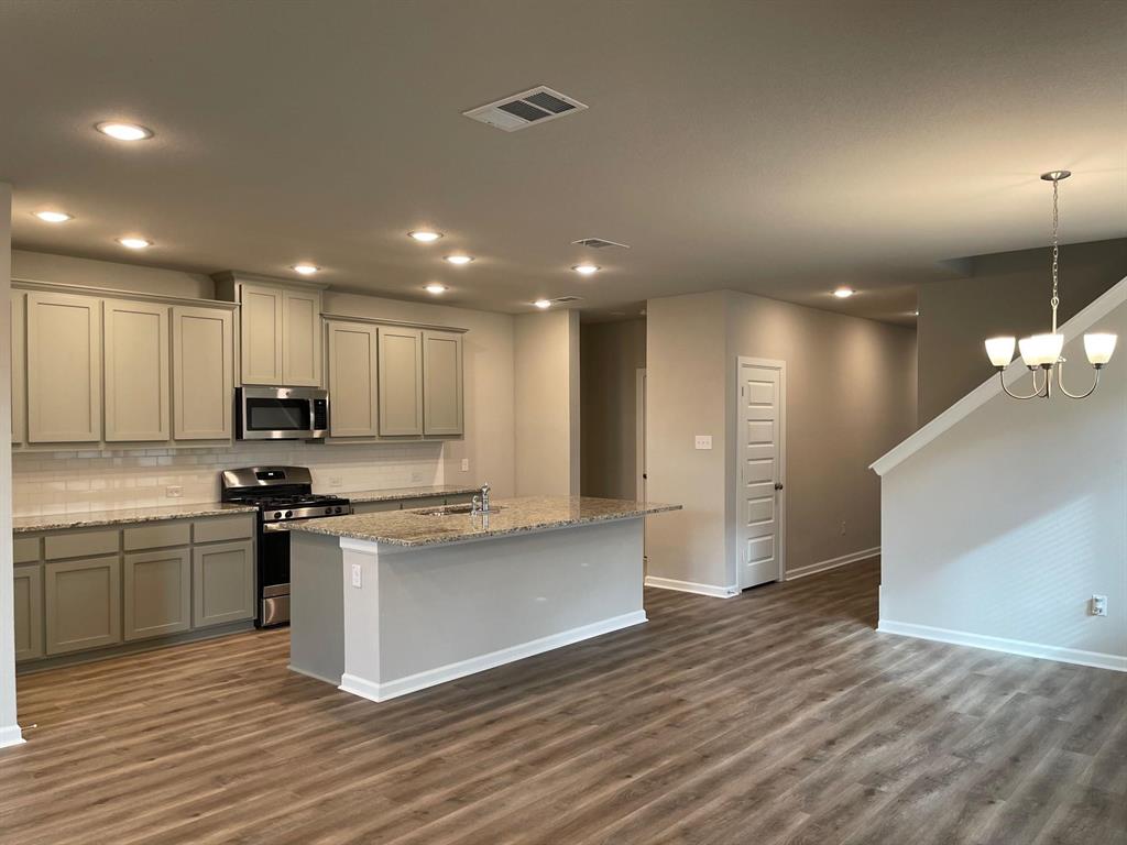 5529 Blue Point Lane Garland, TX 75043 - Photo 5 of 15 a kitchen with stainless steel appliances granite countertop a sink a stove and a refrigerator