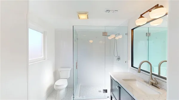 a bathroom with a sink a toilet and shower