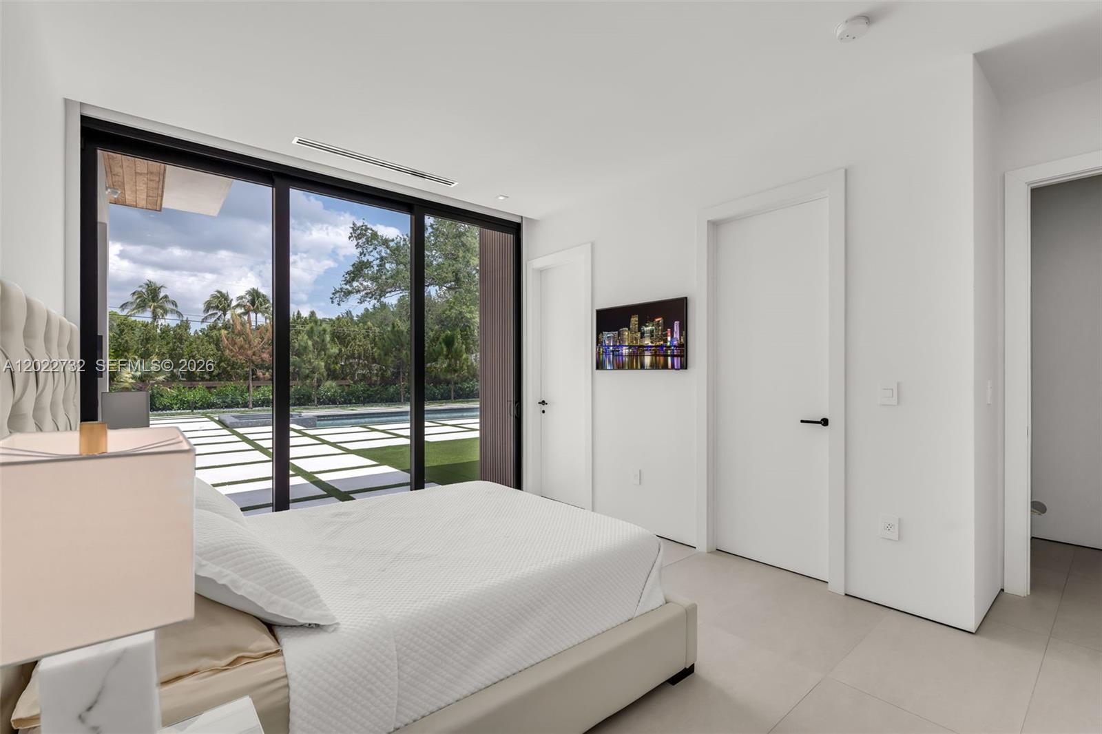 7825 Southwest 128th Street Pinecrest, FL 33156 - Photo 44 of 88 a bedroom with a large bed and a large window