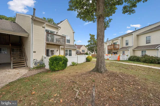 a view of a house with a yard and large tree