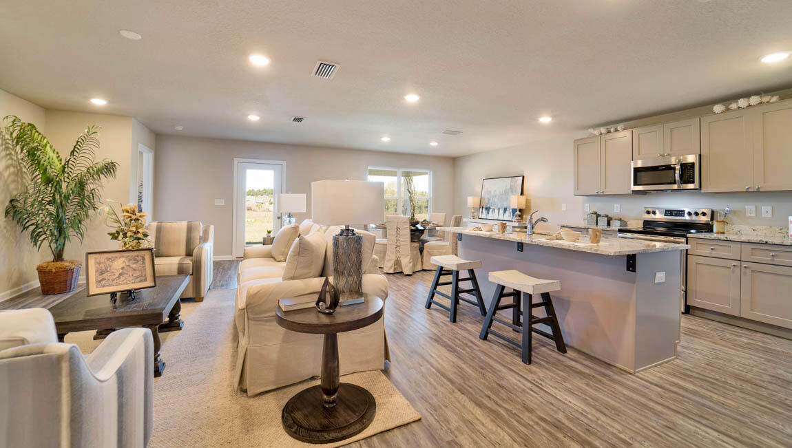 30 Fannin Street Freeport, FL 32439 - Photo 2 of 16 a kitchen with stainless steel appliances kitchen island granite countertop a refrigerator a stove a sink a dining table and chairs with wooden floor