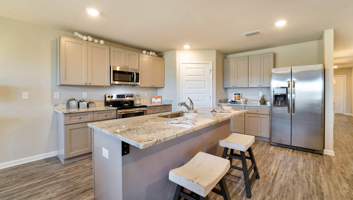 30 Fannin Street Freeport, FL 32439 - Photo 5 of 16 a kitchen with a refrigerator a sink a stove a microwave and cabinets