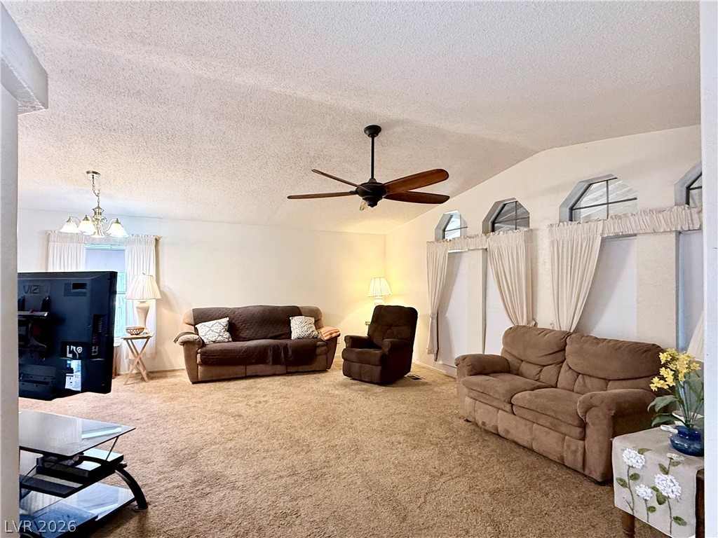 4501 East Kellogg Road Pahrump, NV 89061 - Photo 3 of 52 A comfortable living space boasts vaulted ceilings and generous natural illumination from high arched windows.
