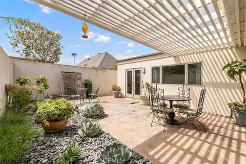 a view of a patio with chairs and potted plants