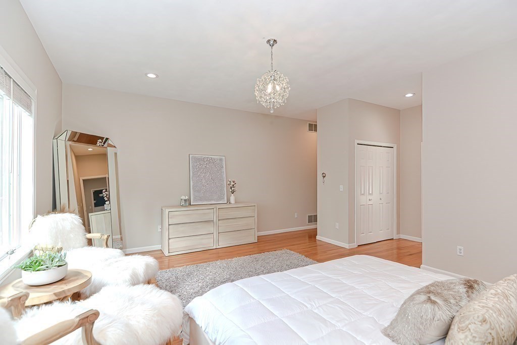 104 Channing Road Concord, MA 01742 - Photo 18 of 36 a bedroom with a bed and chandelier