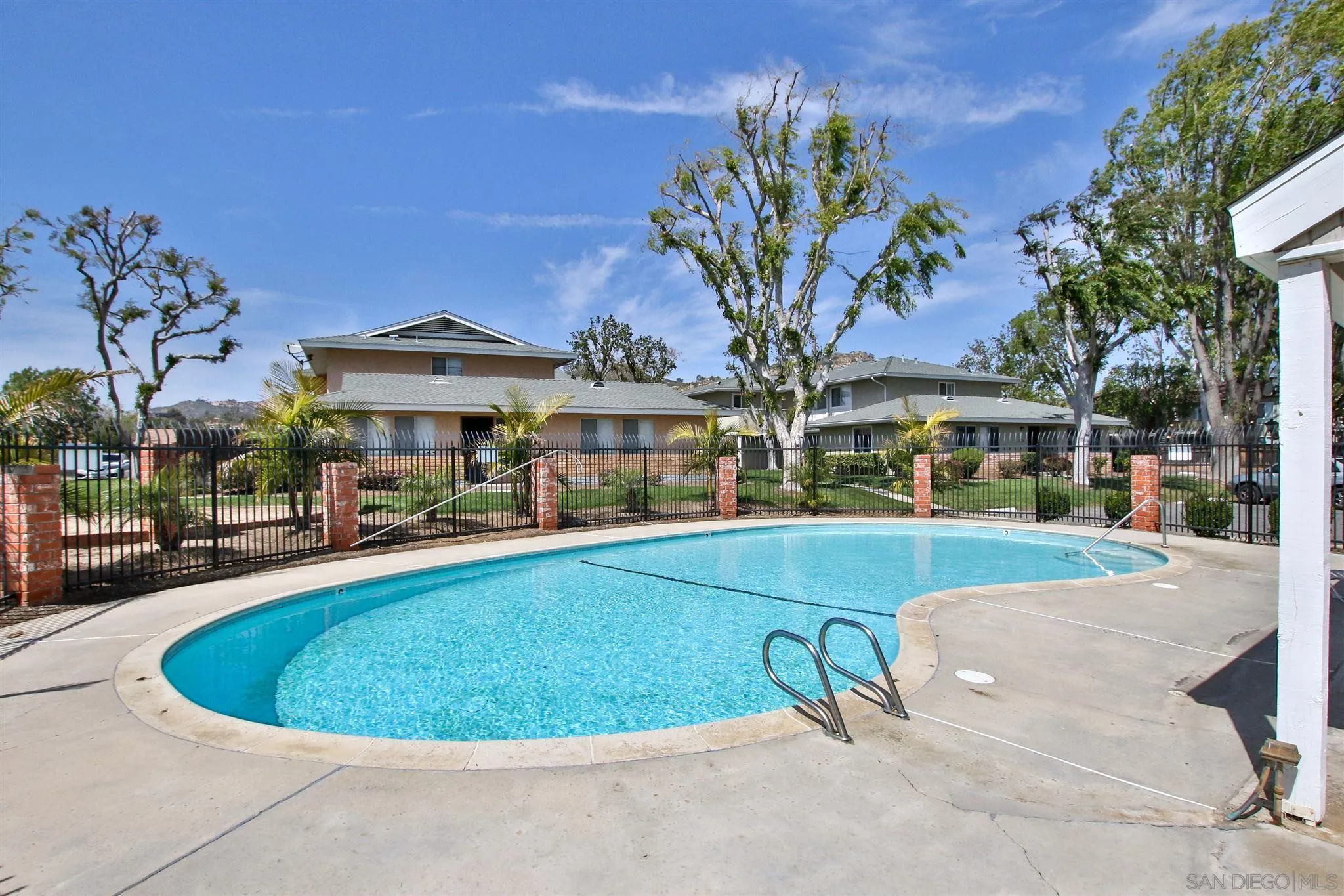 2502 Wanek Road, Unit B Escondido, CA 92027 - Photo 21 of 29 a view of a swimming pool with lawn chairs under an umbrella