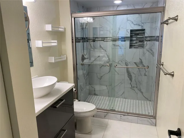 a bathroom with a shower a toilet and a sink