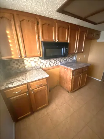 a view of a kitchen with granite countertop a sink and a stove top oven