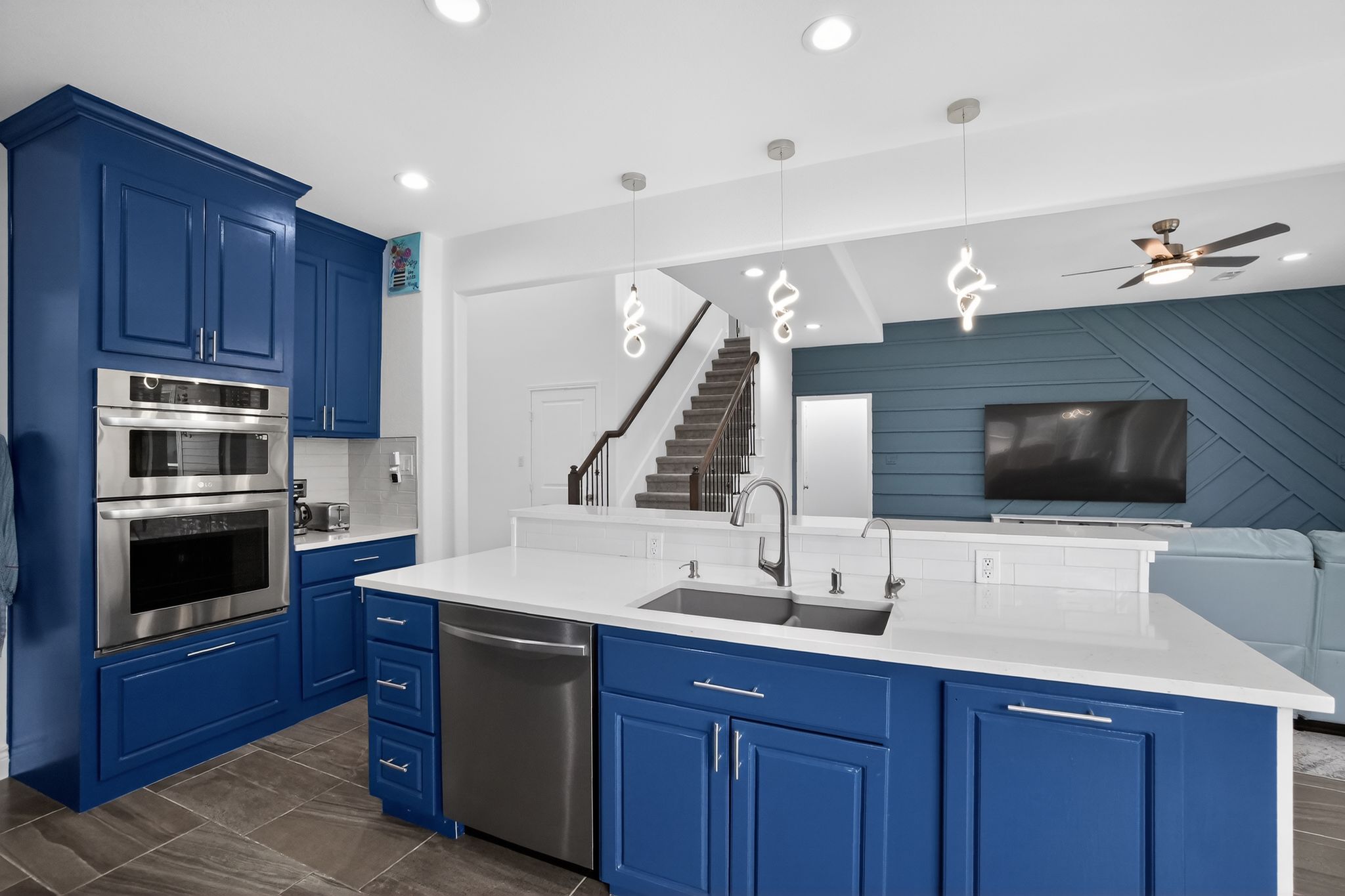 400 Cortona Lane Georgetown, TX 78628 - Photo 37 of 40 Kitchen with blue cabinetry, open floor plan, stainless steel appliances, decorative light fixtures, and an island with sink