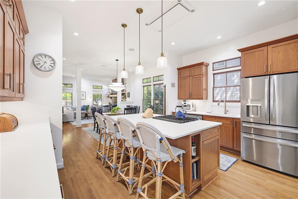 245 Forkner Drive Decatur, GA 30030 - Photo 12 of 31 a open kitchen with stainless steel appliances granite countertop a stove a refrigerator a oven a sink with island chairs and wooden floor