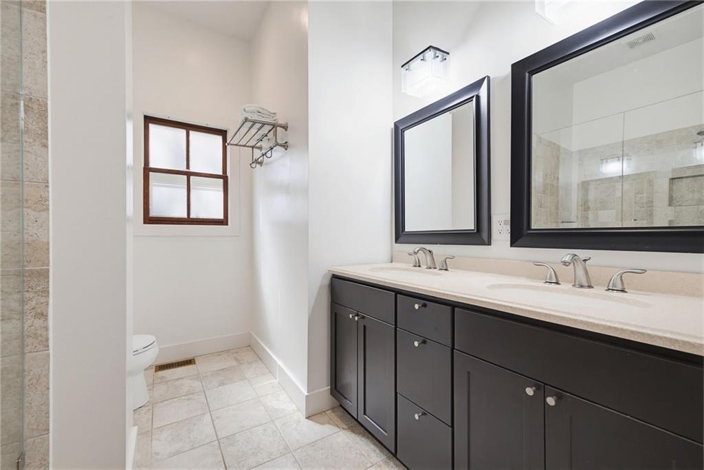 245 Forkner Drive Decatur, GA 30030 - Photo 16 of 31 a bathroom with a double vanity sink a mirror and a