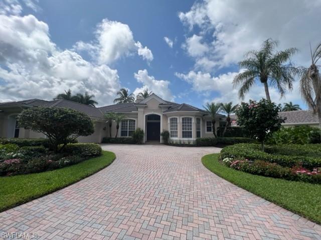938 Spanish Moss Trail Naples, FL 34108 - Photo 11 of 11 a front view of a house with a garden and trees