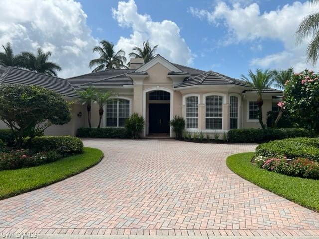 938 Spanish Moss Trail Naples, FL 34108 - Photo 2 of 11 a front view of a house with a garden