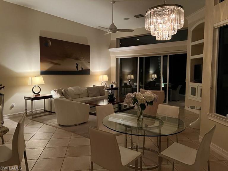 938 Spanish Moss Trail Naples, FL 34108 - Photo 10 of 11 a living room with furniture a chandelier and a view of a dining room