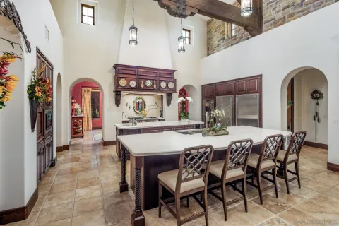 a dining hall with stainless steel appliances granite countertop a dining table and chairs