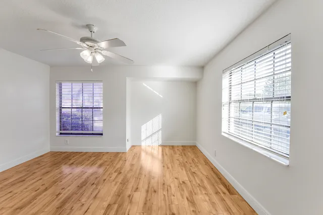 a view of a room with wooden floor and windows
