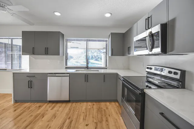 a kitchen with stainless steel appliances granite countertop a sink and a stove