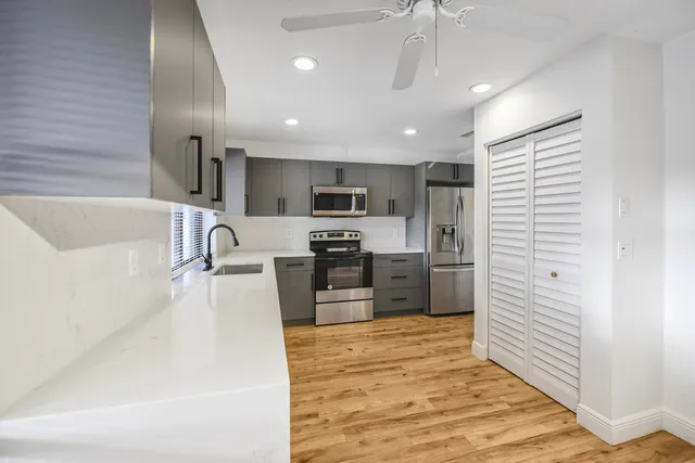 a large kitchen with kitchen island a sink stainless steel appliances and cabinets