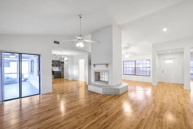 a view of an empty room and window with wooden floor