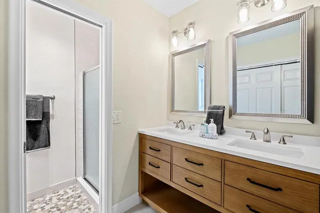 a bathroom with double sink and a mirror
