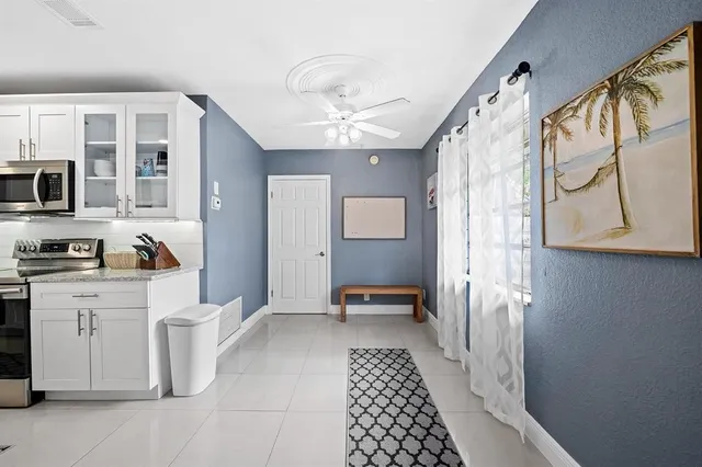 a hallway with white cabinets and window