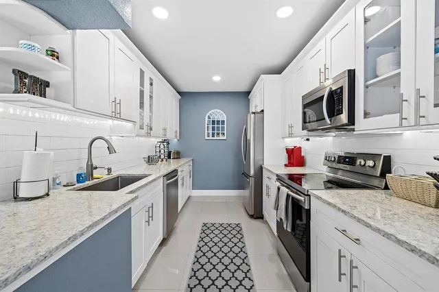 a kitchen with stainless steel appliances granite countertop a sink and a stove