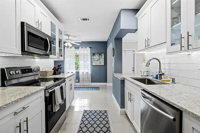 a kitchen with stainless steel appliances granite countertop a sink a stove and a microwave