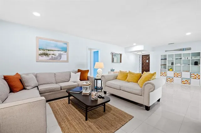 a living room with furniture a rug and a lamp