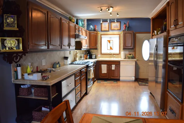 a kitchen with stainless steel appliances granite countertop a sink stove and refrigerator