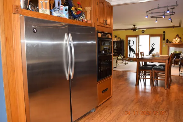 a kitchen with stainless steel appliances granite countertop a refrigerator and wooden floor