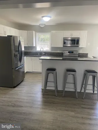 a kitchen with stainless steel appliances granite countertop a refrigerator a stove top oven a sink and dishwasher