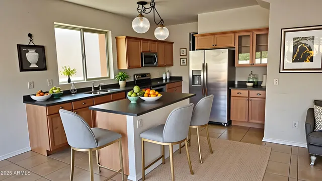 a kitchen with a refrigerator a stove dining table and chairs