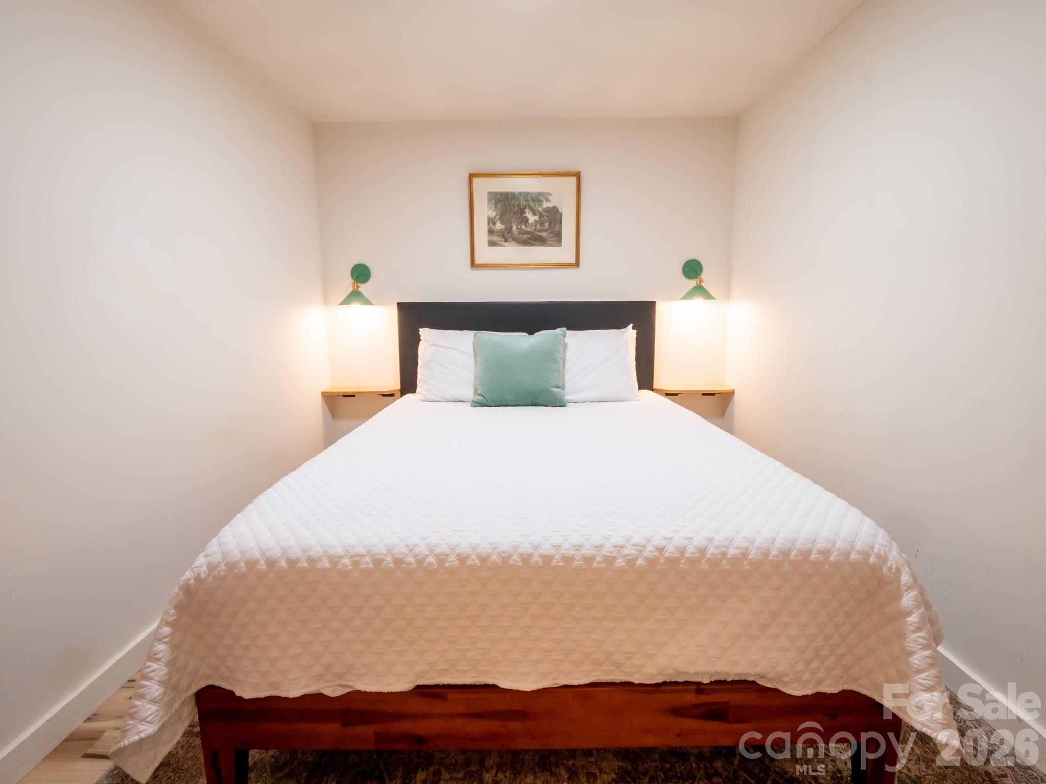 1048 Jenkins Valley Road Alexander, NC 28701 - Photo 18 of 25 a bed sitting in a bedroom with a lamp