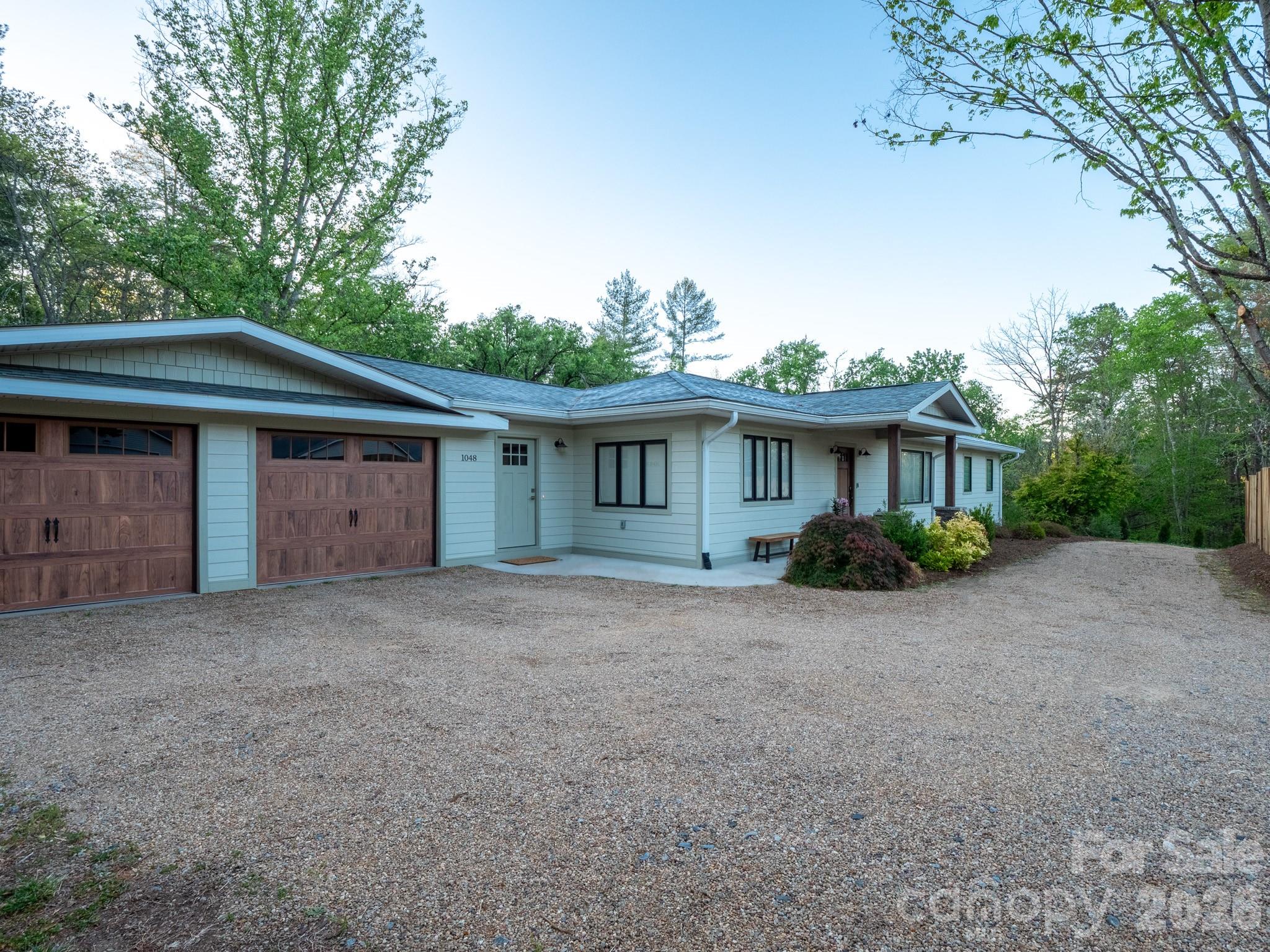 1048 Jenkins Valley Road Alexander, NC 28701 - Photo 2 of 25 a front view of a house with a garden and trees