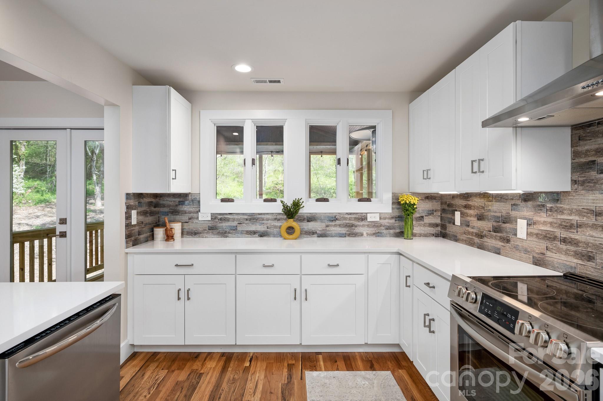 1048 Jenkins Valley Road Alexander, NC 28701 - Photo 7 of 25 a kitchen with granite countertop white cabinets and appliances