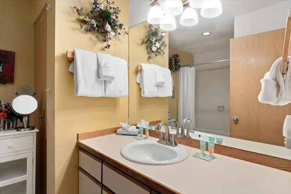 a bathroom with a sink vanity granite and a mirror