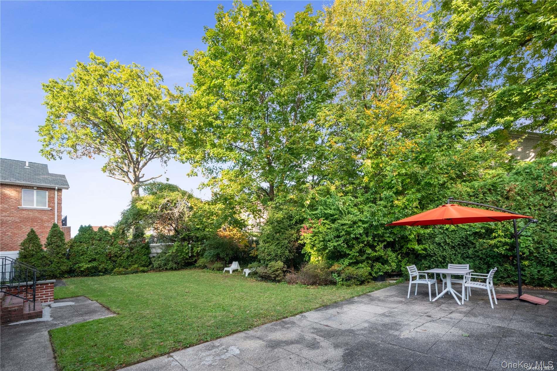 29-33 212th Street, Unit 1F Queens, NY 11360 - Photo 13 of 14 View of green lawn featuring a patio