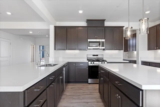 a kitchen with kitchen island granite countertop a sink stove and refrigerator