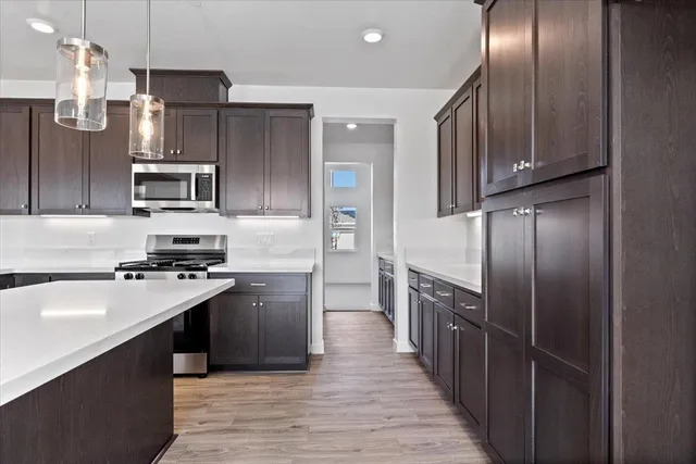 a kitchen with kitchen island granite countertop stainless steel appliances and wooden cabinets