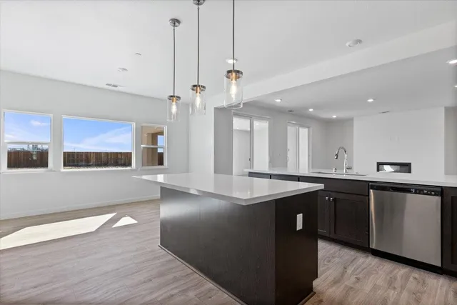 a kitchen with stainless steel appliances granite countertop a sink a stove and wooden floors