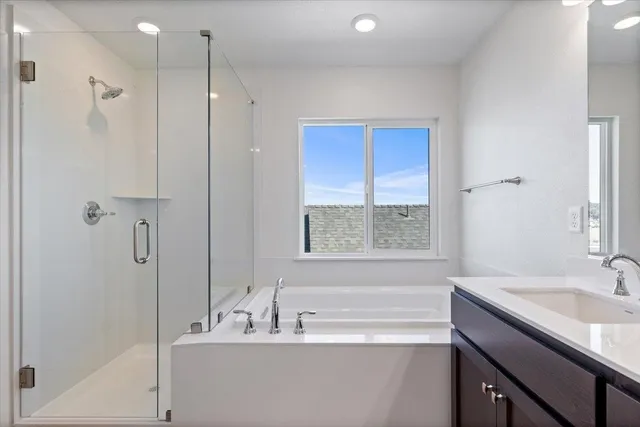 a bathroom with a tub sink shower and mirror