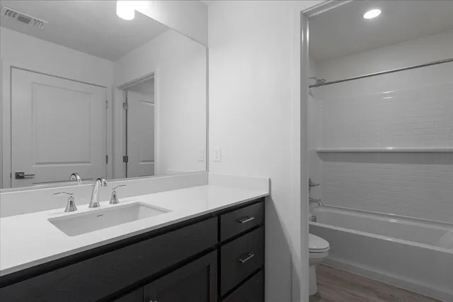 a bathroom with a sink a toilet a shower and a mirror