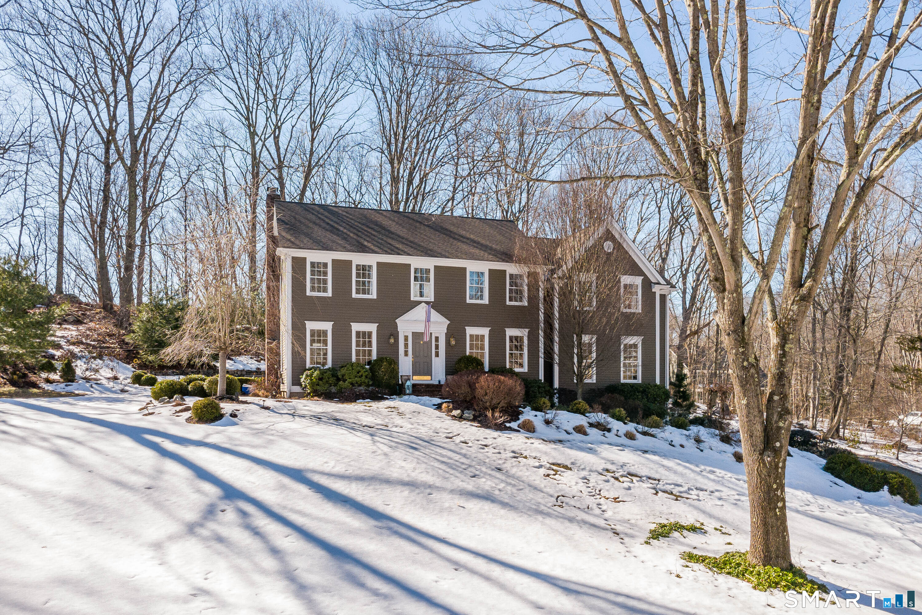 Classic Colonial exterior set on a landscaped property with mature trees.